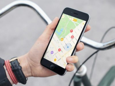 une main tient un téléphone avec l'application mapstr ouverte