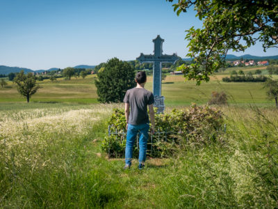 Un randonneur se tient devant la tombe d'un soldat prussien tombé au combat lors de la bataille de Wœrth-Frœschwiller en Alsace